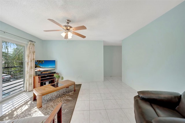 living room featuring light tile patterned floors, a textured ceiling, and ceiling fan