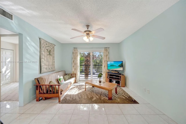 living room with light tile patterned floors, a textured ceiling, and ceiling fan