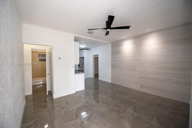 spare room featuring ceiling fan and a textured ceiling