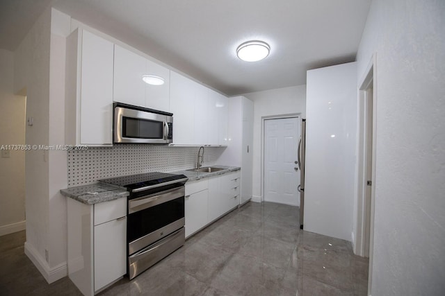 kitchen with white cabinetry, sink, decorative backsplash, and stainless steel appliances