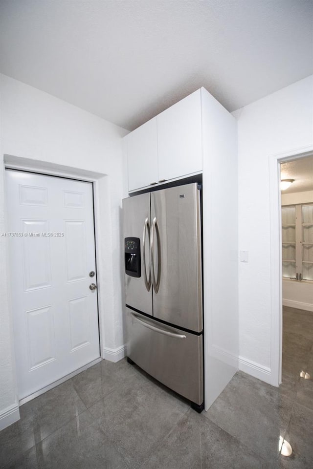 kitchen featuring stainless steel fridge and dark tile patterned floors