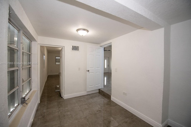 unfurnished room featuring a textured ceiling