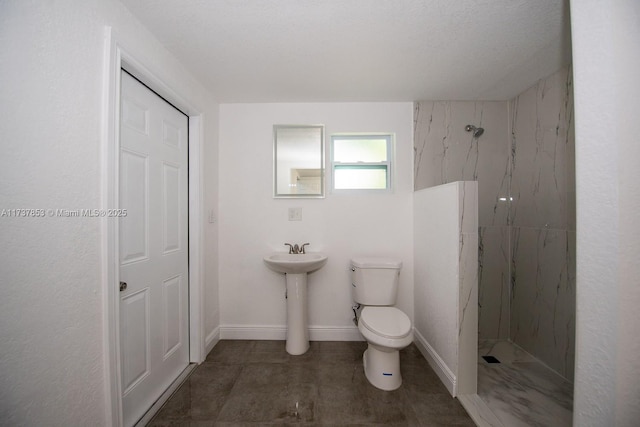 bathroom featuring a tile shower and toilet