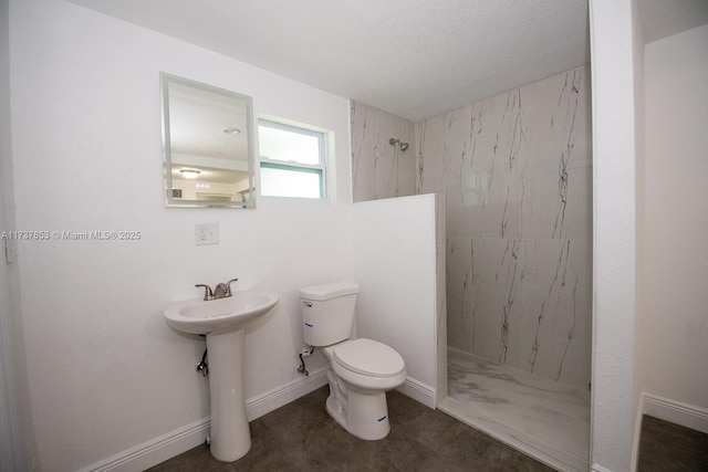 bathroom featuring tiled shower and toilet