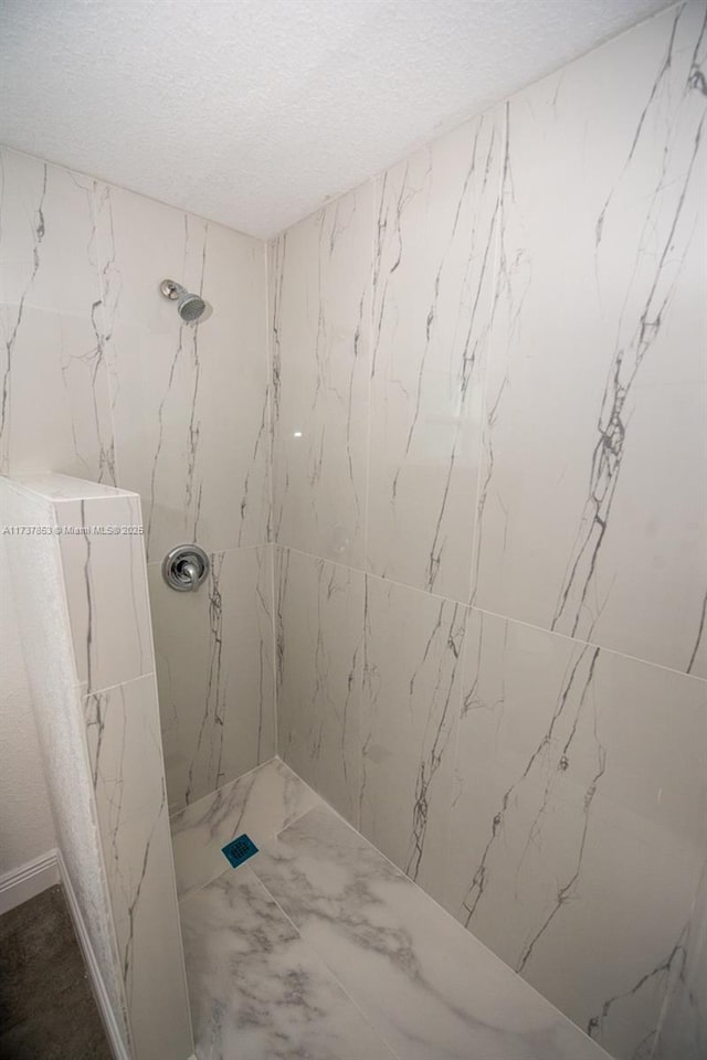 bathroom featuring tiled shower and a textured ceiling