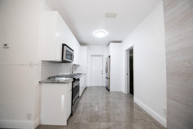 kitchen featuring stainless steel appliances, sink, white cabinets, and decorative backsplash