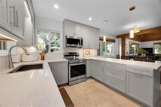 kitchen featuring stainless steel appliances, sink, pendant lighting, and gray cabinets