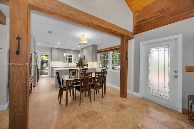 dining area featuring vaulted ceiling with beams