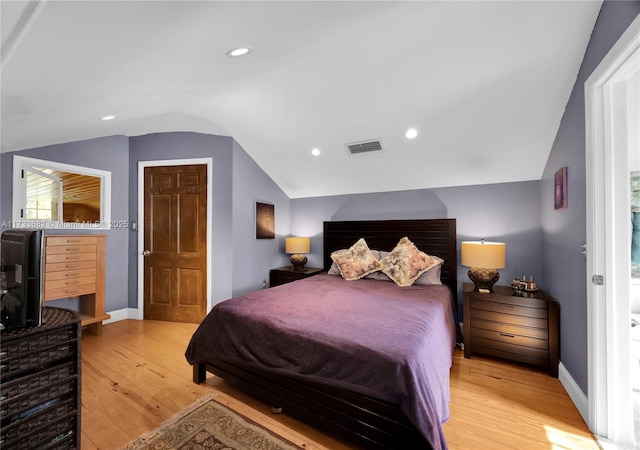 bedroom featuring lofted ceiling and light hardwood / wood-style floors