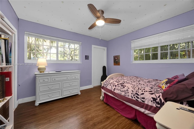 bedroom with multiple windows, ceiling fan, and dark hardwood / wood-style flooring