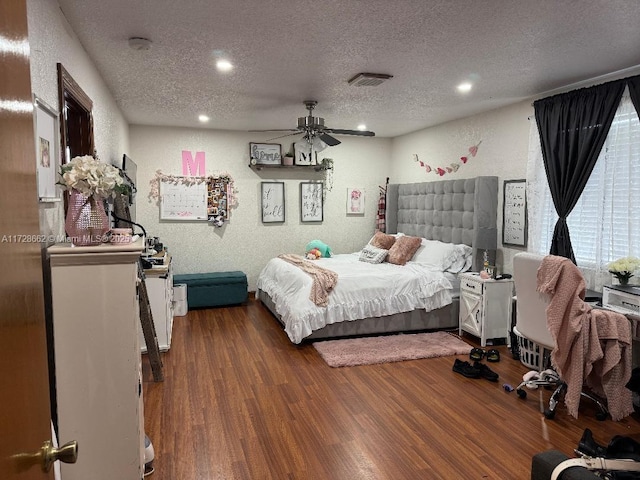 bedroom with hardwood / wood-style flooring, ceiling fan, and a textured ceiling