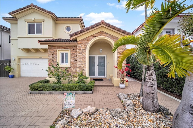 mediterranean / spanish home with a garage and french doors