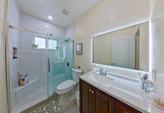 bathroom featuring vanity, toilet, and a shower with shower door