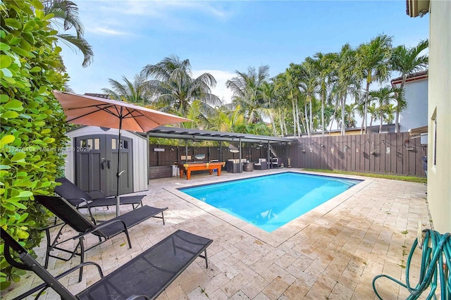 view of swimming pool with a storage shed and a patio area