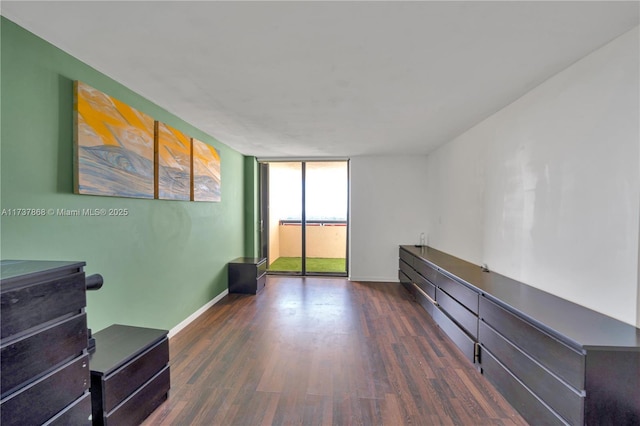 spare room with dark wood-type flooring and a wall of windows