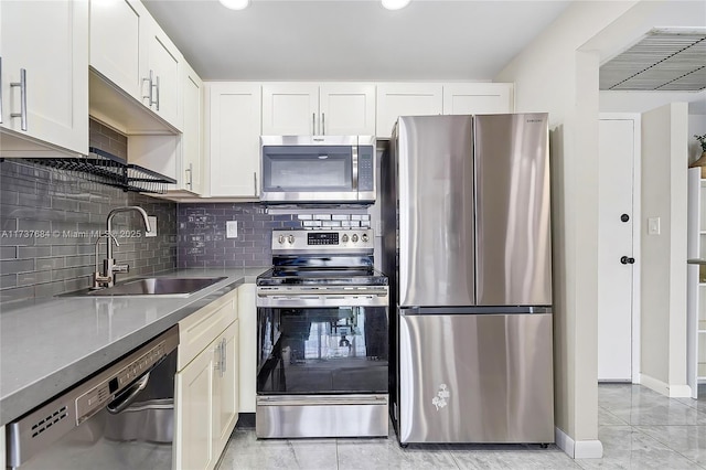 kitchen with stone counters, appliances with stainless steel finishes, white cabinetry, sink, and decorative backsplash