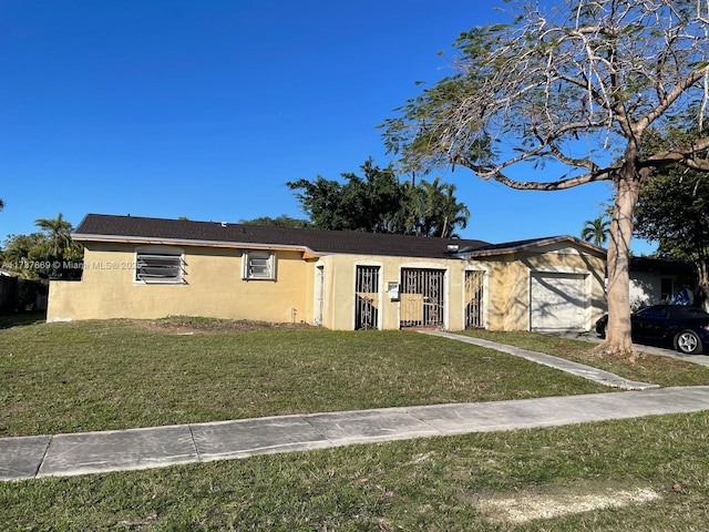 single story home featuring a garage and a front lawn