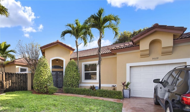 mediterranean / spanish home with a garage, french doors, and a front lawn