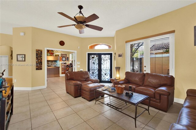 tiled living room featuring a textured ceiling, french doors, and ceiling fan