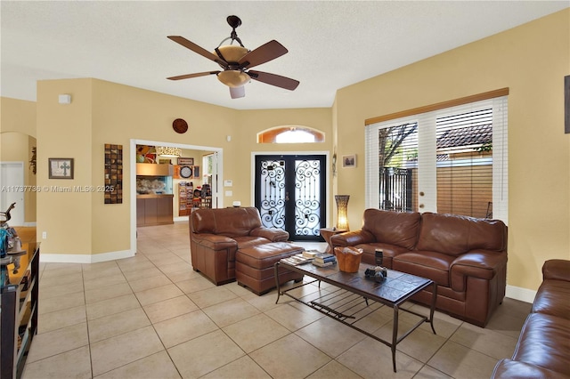 living room with ceiling fan, light tile patterned flooring, baseboards, and french doors