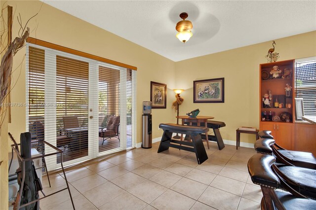 tiled office space featuring ceiling fan