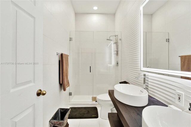 bathroom featuring tile walls, vanity, tile patterned floors, toilet, and walk in shower