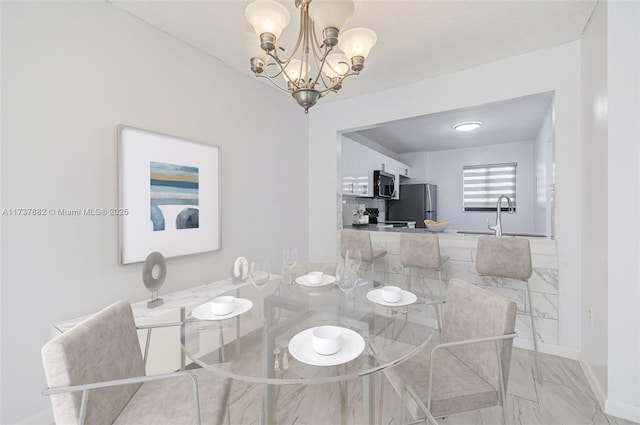 dining space featuring sink and a chandelier