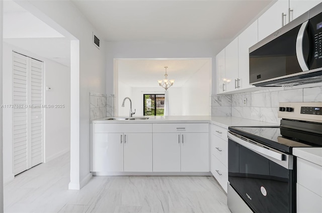 kitchen with sink, decorative light fixtures, stainless steel appliances, decorative backsplash, and white cabinets