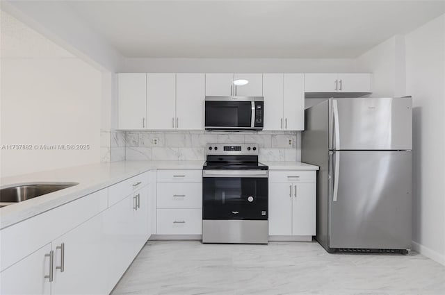 kitchen with white cabinetry, tasteful backsplash, and stainless steel appliances