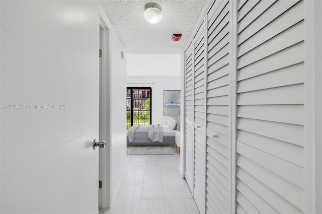 hall with a textured ceiling