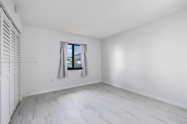 unfurnished room with a textured ceiling