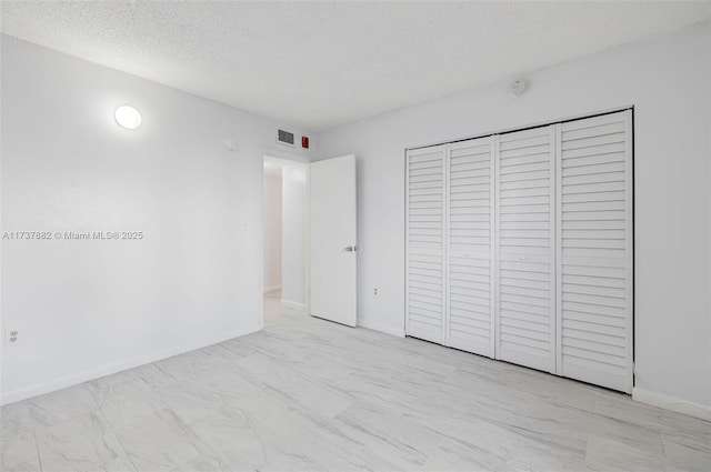 unfurnished bedroom featuring a closet and a textured ceiling