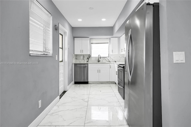 kitchen featuring white cabinetry, appliances with stainless steel finishes, sink, and decorative backsplash