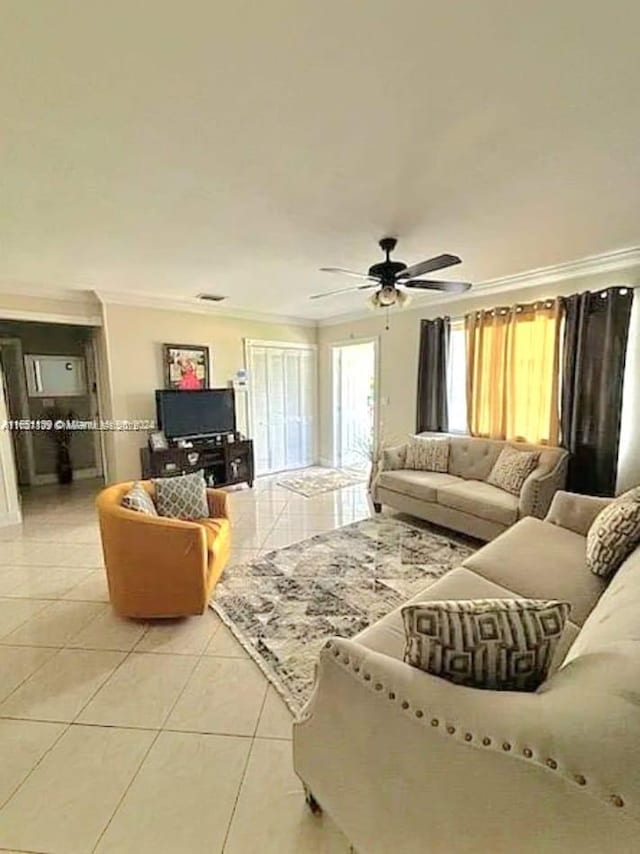 living room with light tile patterned floors, crown molding, and ceiling fan