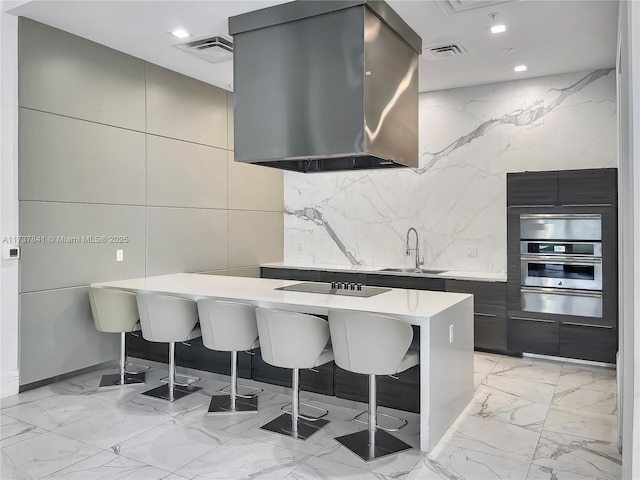4745 NW 84th Ct Unit 15, Doral, FL 33166 - kitchen featuring a breakfast bar, light countertops, stainless steel oven, range hood, and a sink