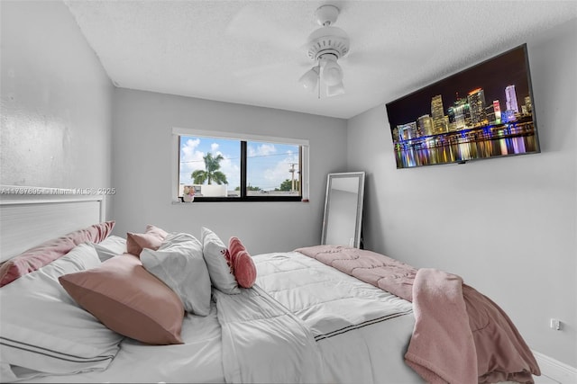 bedroom with ceiling fan and a textured ceiling