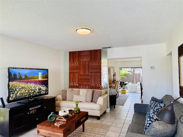 living room with a textured ceiling and light tile patterned flooring