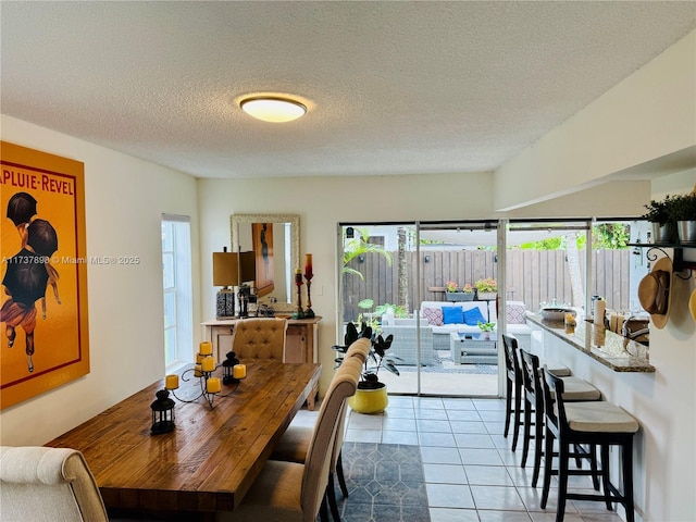 dining area featuring light tile patterned flooring and a textured ceiling