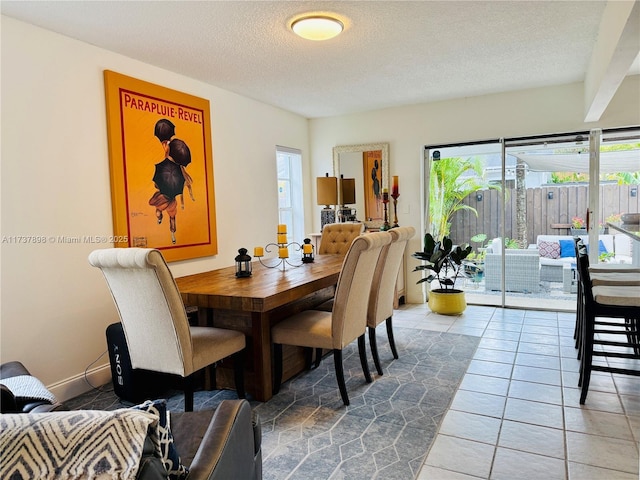 dining room with a healthy amount of sunlight, tile patterned floors, and a textured ceiling