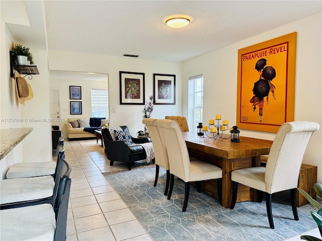 tiled dining room with plenty of natural light and a textured ceiling