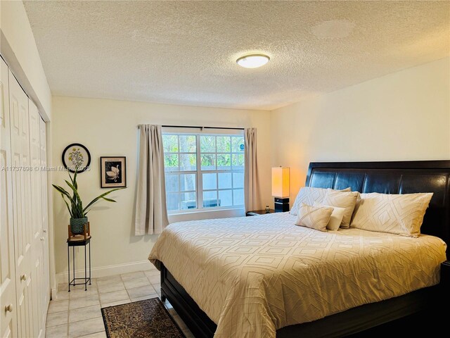 tiled bedroom featuring a textured ceiling and a closet