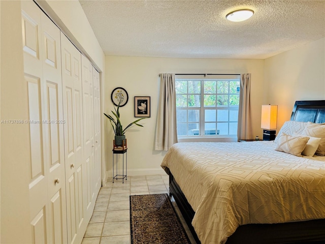 tiled bedroom with a closet and a textured ceiling