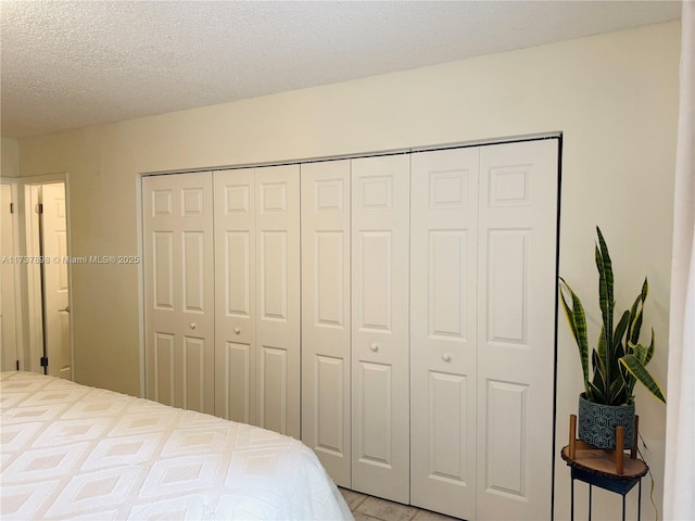 bedroom with a textured ceiling and a closet