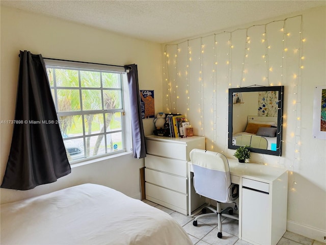 bedroom featuring light tile patterned floors and a textured ceiling