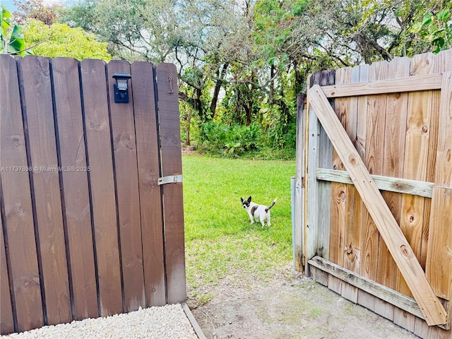 view of gate with a lawn