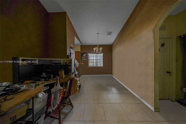 interior space featuring lofted ceiling, light tile patterned floors, and a notable chandelier