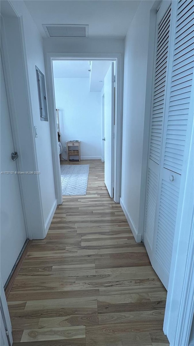 hallway with light hardwood / wood-style floors