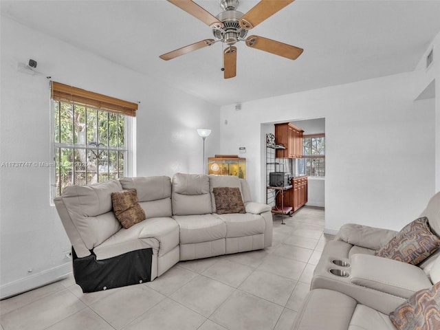 tiled living room with ceiling fan and a healthy amount of sunlight