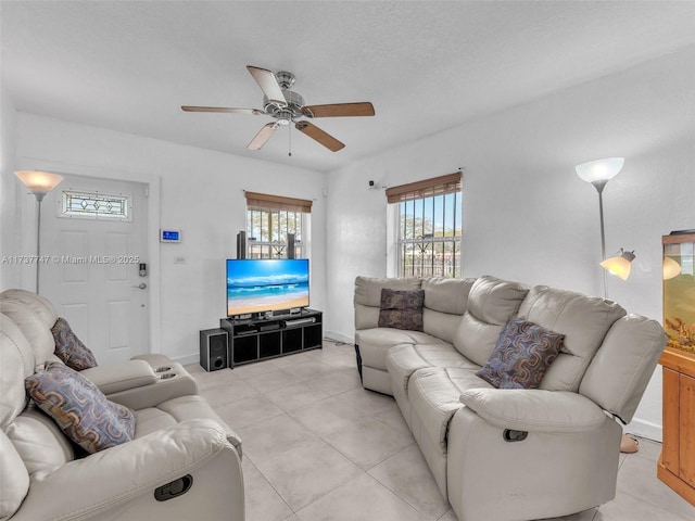 living room featuring light tile patterned floors, a textured ceiling, and ceiling fan