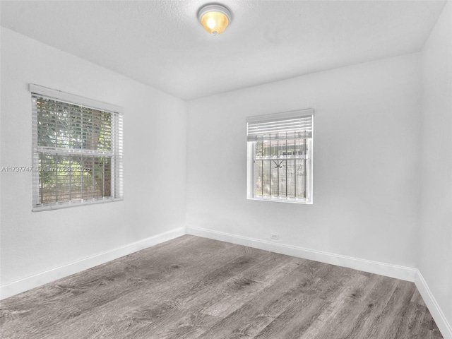 unfurnished room with hardwood / wood-style flooring